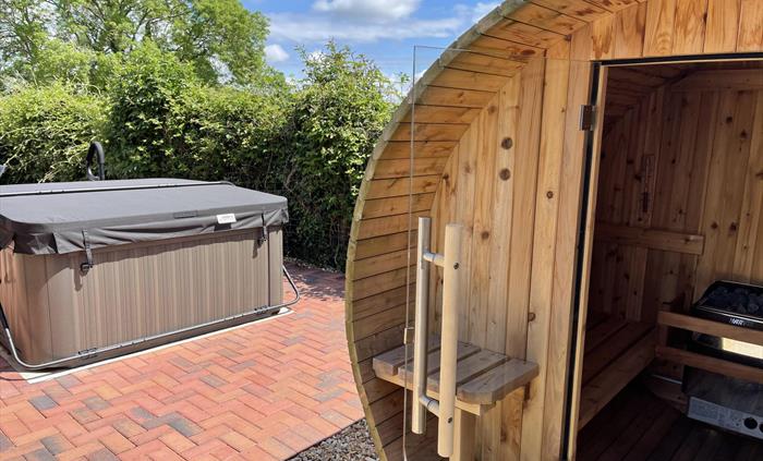 Shows lockable private garden area at the rear of Blackthorn Lodge. Offers a Red Cedar Barrel Sauna, a Jacuzzi, garden table and 4 chairs